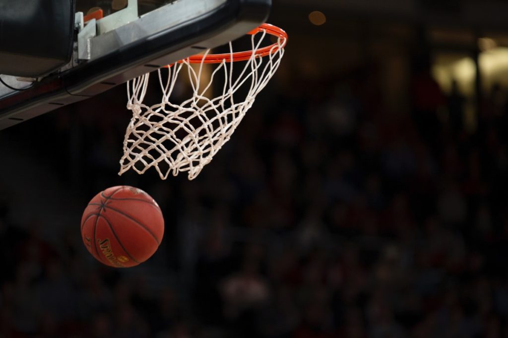 Basketball falling through the hoop and net.