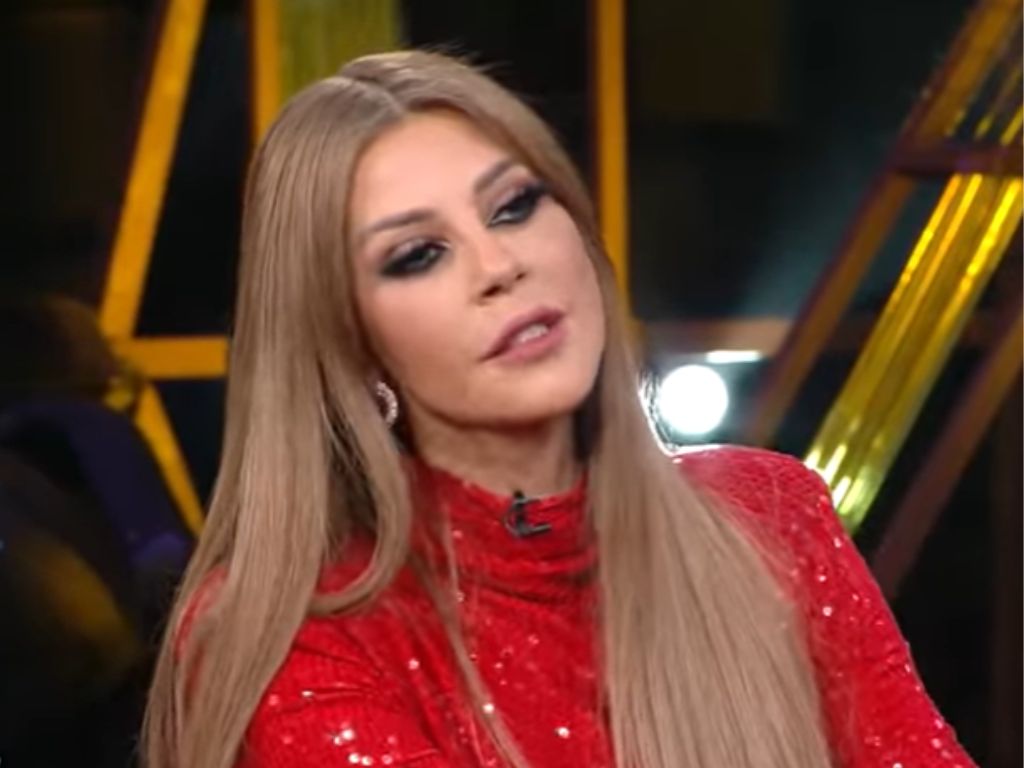 Carla Diab during a television appearance, wearing a red sparkly dress.