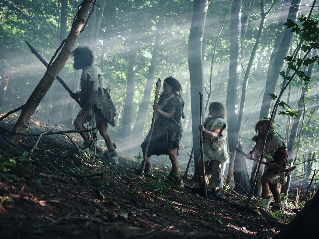 Tribe of Hunter-Gatherers Wearing Animal Skin Holding Stone Tipped Tools