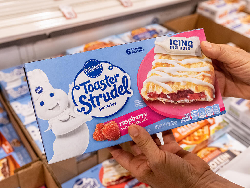 shoppers hand holding a package of Pillsbury brand frozen raspberry toaster strudels on a supermarket aisle