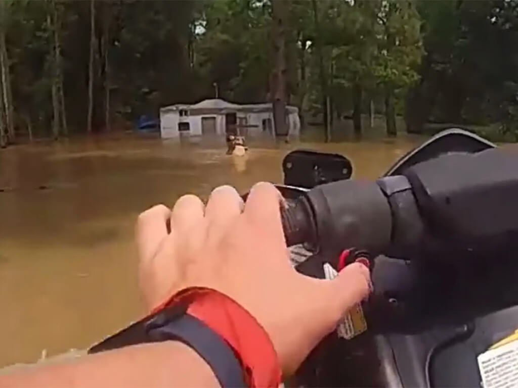 A Houston police officer used a personal watercraft to rescue a man and three dogs amid severe flooding in Texas on Saturday.